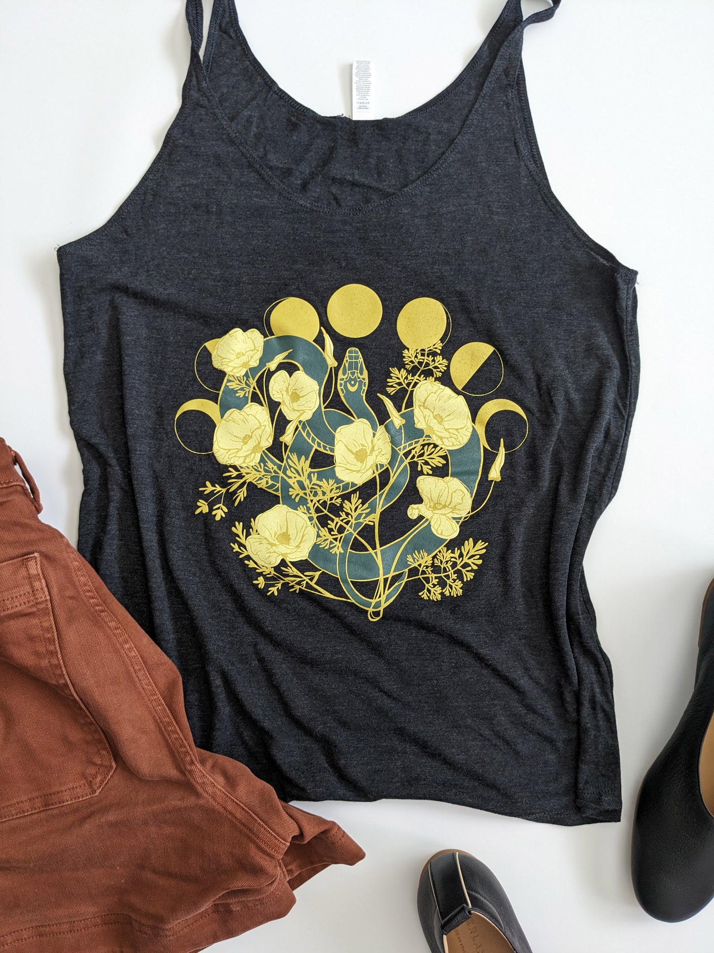 This super soft tank top features a snake among poppy flowers and the phases of the moon.